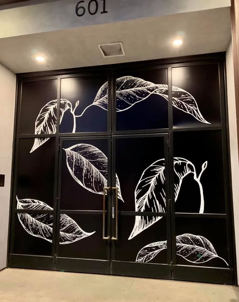 Black door with white leaf design